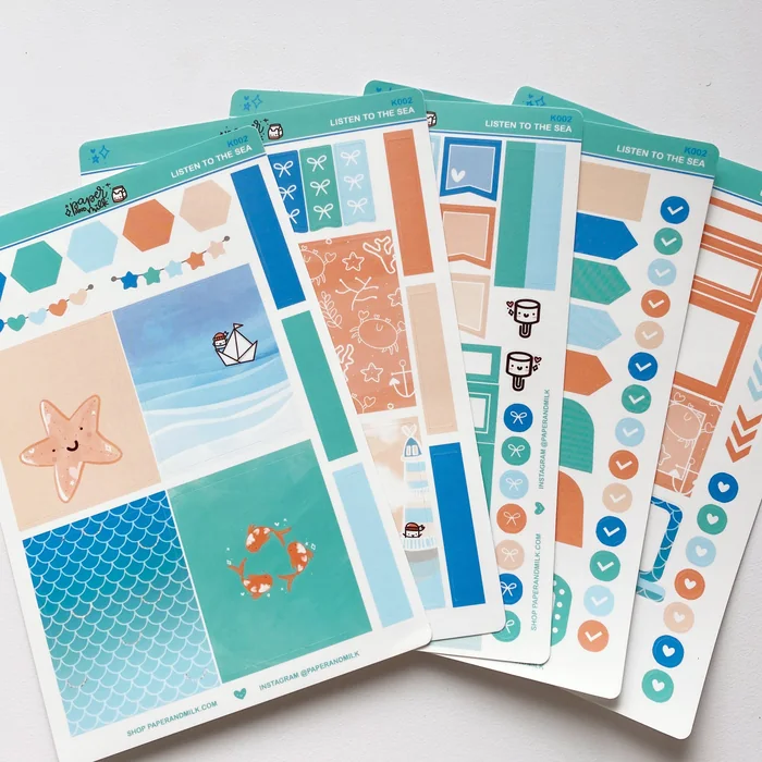 A fanned set of teal and orange beach-themed planner sticker sheets