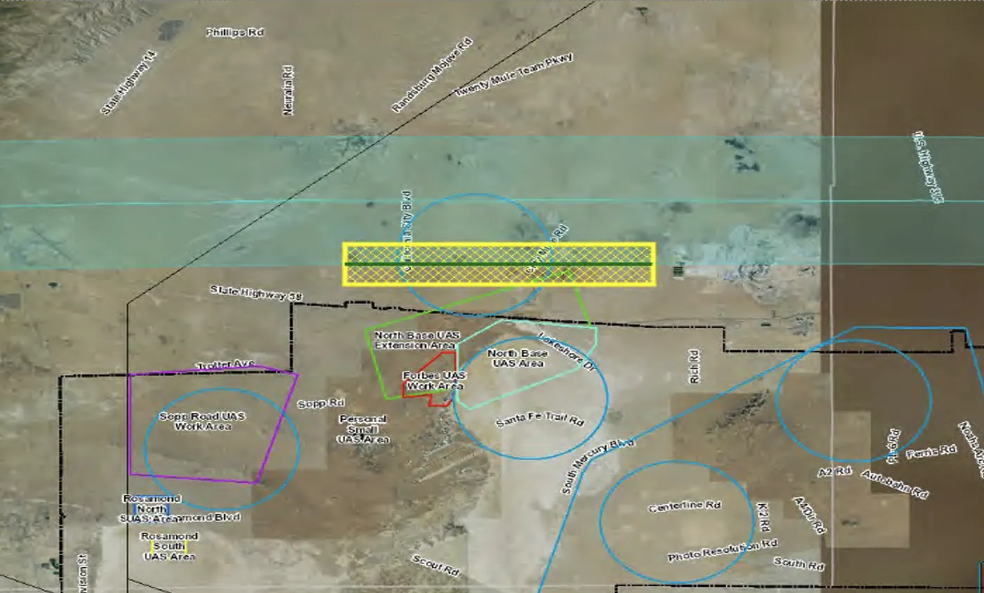 Public satellite map of a desert test range with airspace boundaries drawn over it as colored circles, polygons and a hatched yellow corridor, each labeled as a work area